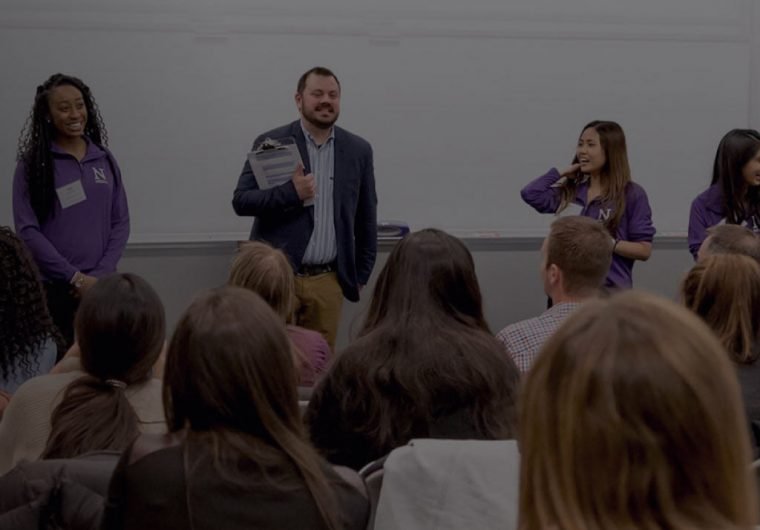 A background image for Northwestern Medill of a professor giving a speech